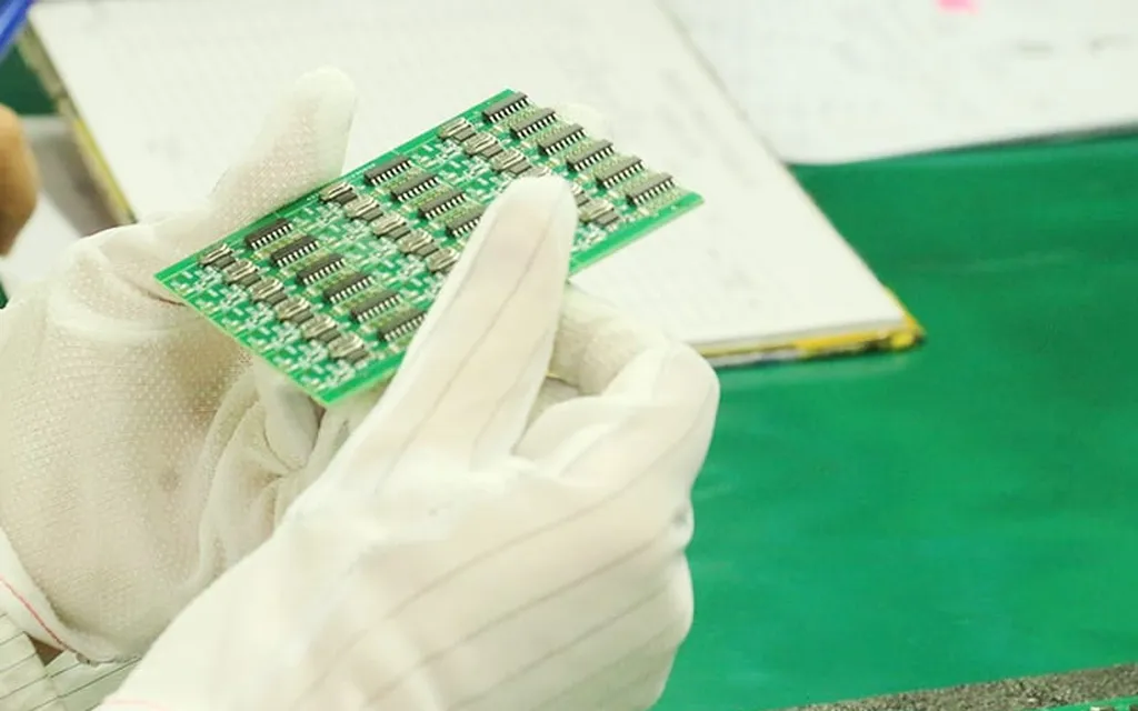 White-glove inspection of multi-chip green board — medical-grade assembly