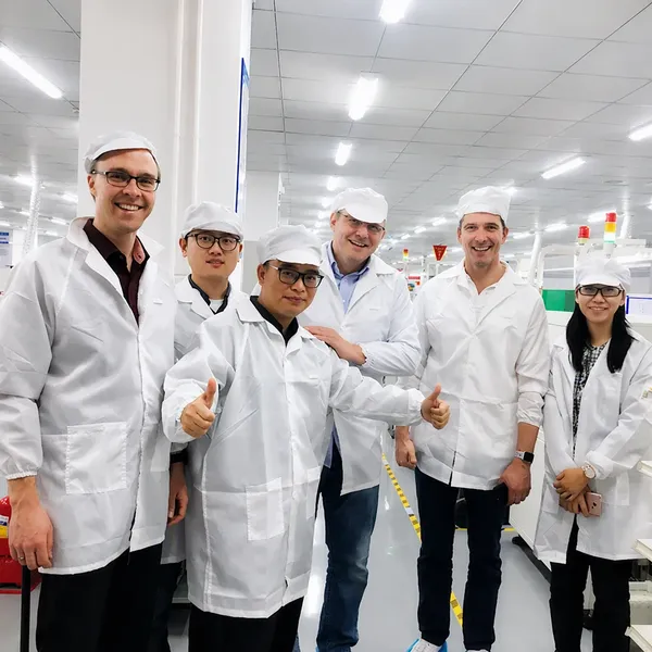 Six-member team in white coats during a cleanroom tour